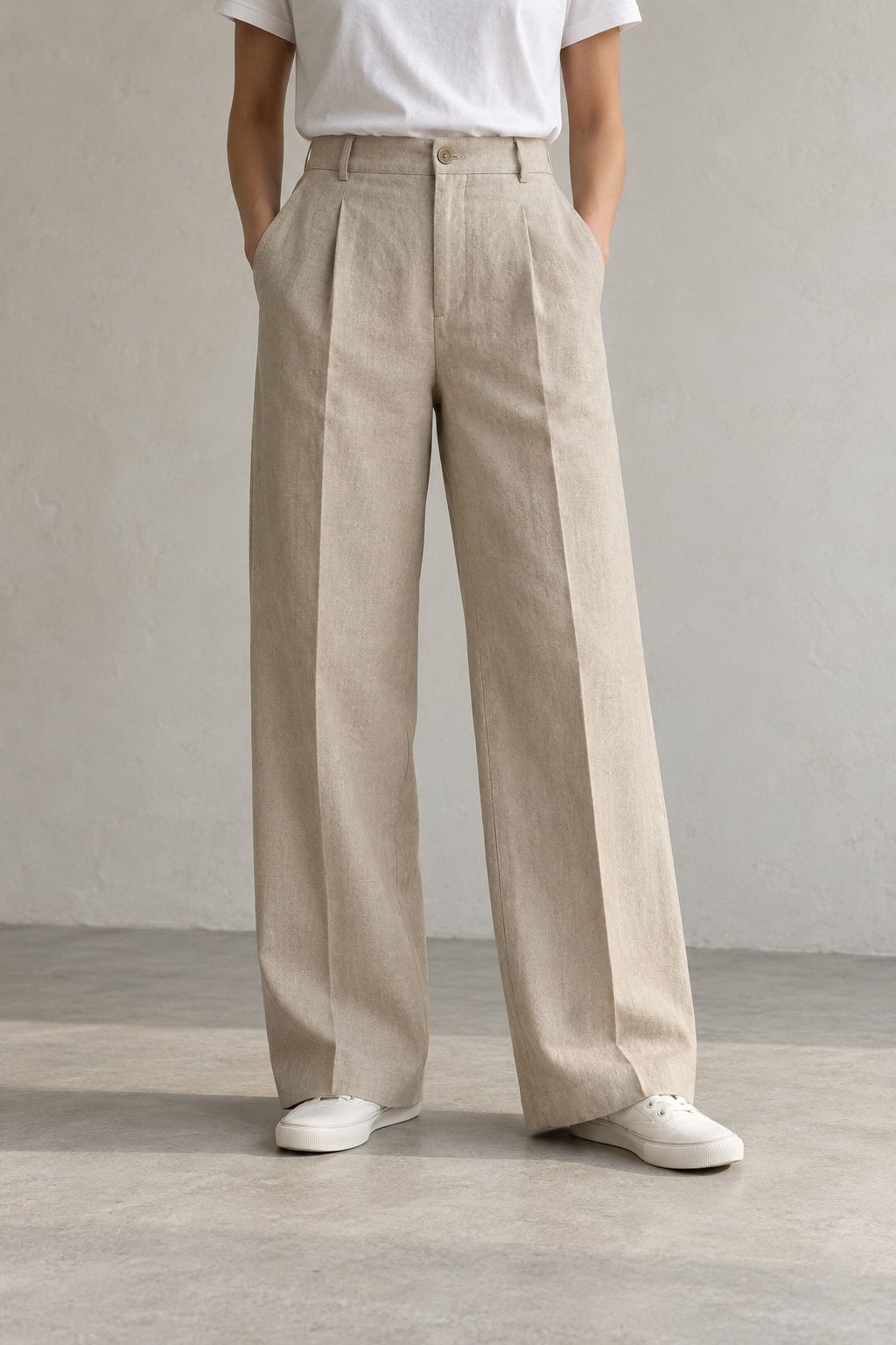 Halden wide trouser in flax, worn with a white tee, seen from the waist down against a plaster wall